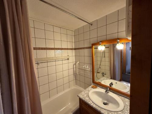 une salle de bain avec un lavabo, une baignoire et un miroir dans l'établissement Appartement spacieux au cœur de Belle Plagne - 5 pers - FR-1-181-2849, à La Plagne Tarentaise