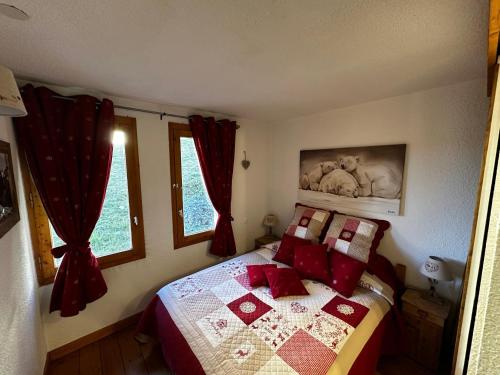 une chambre avec un lit avec des oreillers rouges dans l'établissement Appartement spacieux au cœur de Belle Plagne - 5 pers - FR-1-181-2849, à La Plagne Tarentaise
