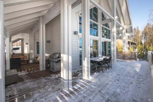 a screened porch of a house with a table and chairs at Villa Lago, Tahko in Tahkovuori