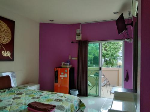 a bedroom with purple walls and a bed and a window at Donchai House Guest House& Cafe in Chiang Mai