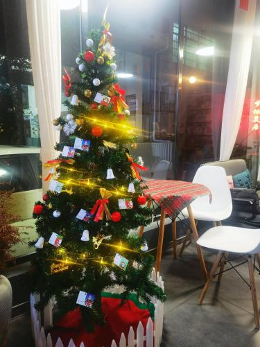 a christmas tree in a room with a table and chairs at Zhangjiajie Twelve Warm Inn-Tianmen Mountain Ropeway Station in Zhangjiajie