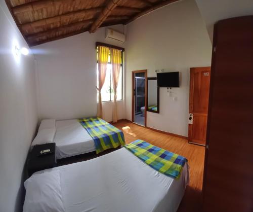 a bedroom with two twin beds and a television at Finca Hotel Santaleja in La Tebaida