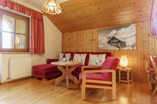 a living room with a couch and a table and chairs at Landhaus Birgbichler - Apartments in Ramsau am Dachstein - inklusive SOMMERCARD! in Ramsau am Dachstein