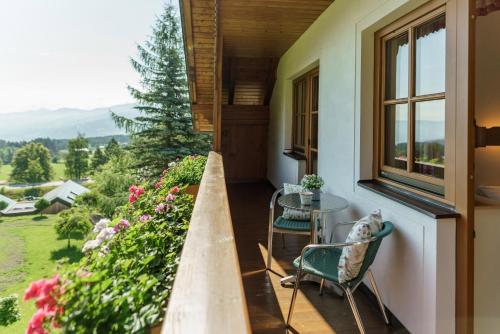 a porch with a table and chairs and a window at Landhaus Birgbichler - Apartments in Ramsau am Dachstein - inklusive SOMMERCARD! in Ramsau am Dachstein