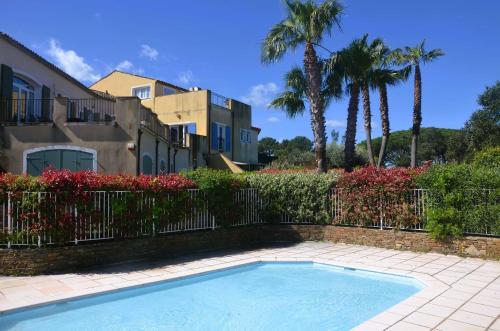 une piscine devant une maison avec des palmiers dans l'établissement Cogestelle - Golfe de St-Tropez - Belle vue dominante, à Cogolin