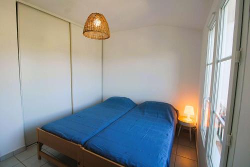 - une petite chambre avec un lit bleu et une fenêtre dans l'établissement Cogestelle - Golfe de St-Tropez - Belle vue dominante, à Cogolin