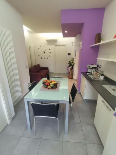 a kitchen with a table with a bowl of fruit on it at Casa Violetta in Alba