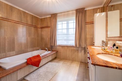 a bathroom with a tub and a sink at Villa Blauw in De Panne