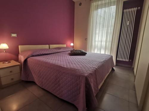 a bedroom with a bed with a purple comforter at Casa Violetta in Alba