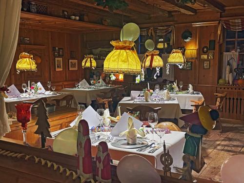 a dining room with white tables and yellow chandeliers at Hotel Restaurant Rengser Mühle in Bergneustadt