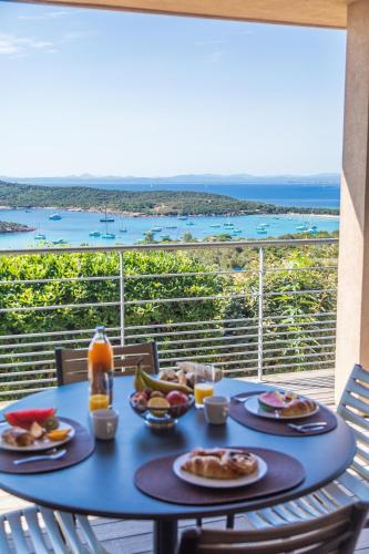 a blue table with food on top of a balcony at Résidence Les Terrasses de Rondinara in Bonifacio