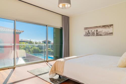 een slaapkamer met een bed en een groot raam bij Villa Nogueira V with Private Pool by Holiday Rental Madeira in Funchal
