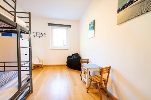 a bedroom with a table and a bunk bed at Fleischerei - Apartments, Cafe & Weinbar in Hinterstoder