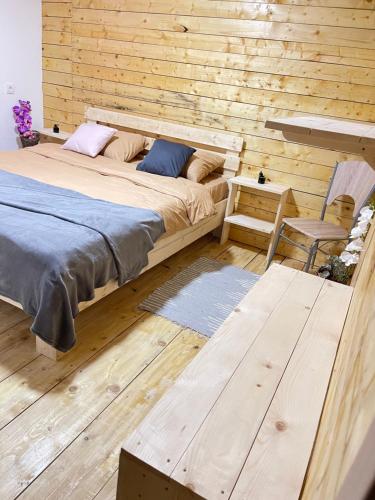 a bedroom with a bed and a wooden wall at Šumska vila Gašić in Kopaonik