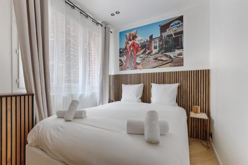 une chambre avec un grand lit blanc avec deux oreillers dans l'établissement Luxury Apartment Trocadero 2BR, à Paris