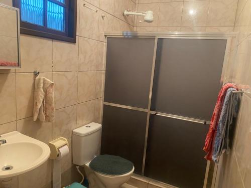 a bathroom with a shower with a toilet and a sink at Casa por do sol Angra in Angra dos Reis