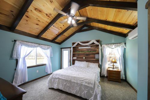 una camera da letto con un letto e un soffitto in legno di Eagle Lake Cottage a Dunnville