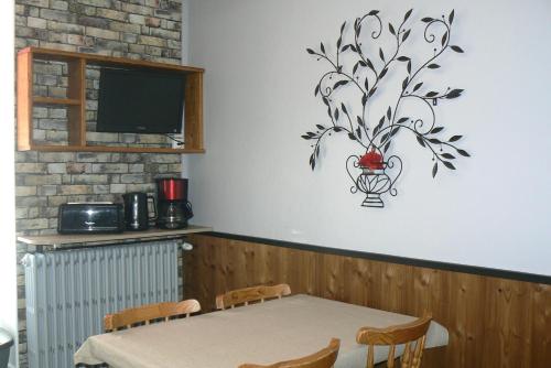 une table à manger avec un vase sur le mur dans l'établissement La Coudraie Villa des Familles, à La Bourboule