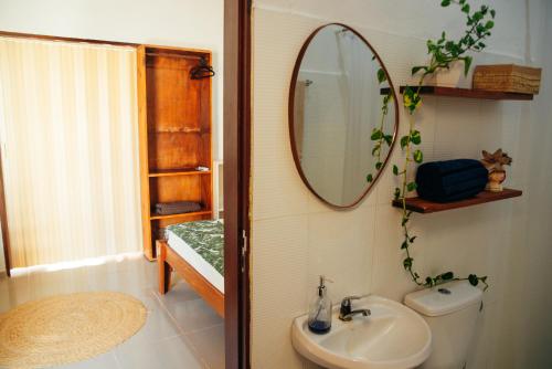 Un baño con un lavabo y un espejo en la pared. en Dunas Pipa acomodações, en Pipa