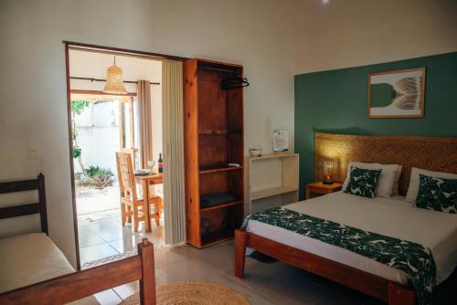 Un dormitorio con una cama y una puerta a un patio. en Dunas Pipa acomodações, en Pipa