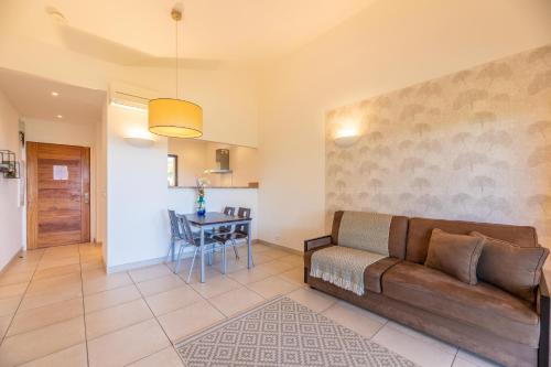 a living room with a couch and a table at Résidence Les Terrasses de Rondinara in Bonifacio