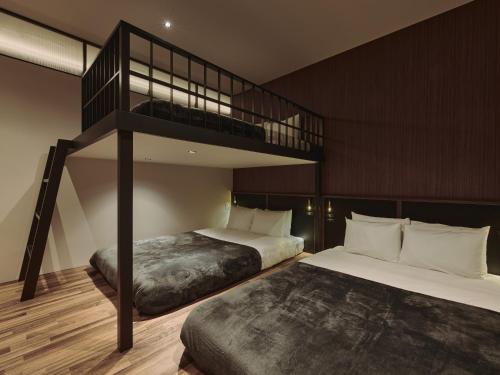 a bedroom with two beds and a bunk bed at illi Gran Azabujuban in Tokyo