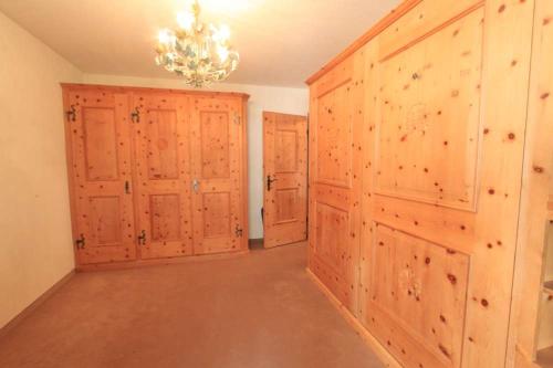 a large room with wooden doors and a chandelier at Apartment Christina in Pontresina