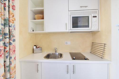 a kitchen with a sink and a microwave at Belvair 37 in Zuoz