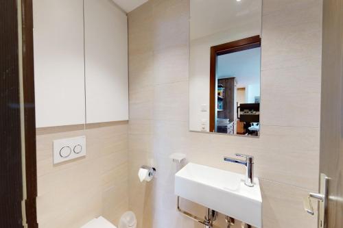 un bagno con lavandino e specchio di Apartment Gianda Verda C31 a Surlej