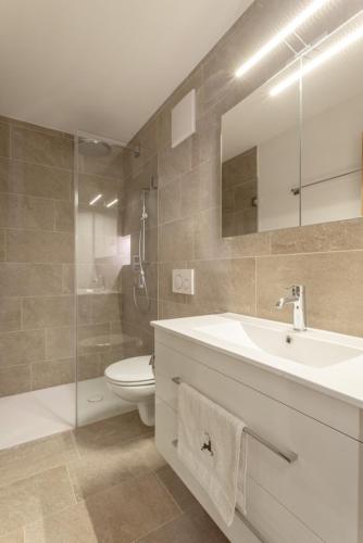 a bathroom with a sink and a toilet and a shower at Apartment Arsa 15 in Silvaplana