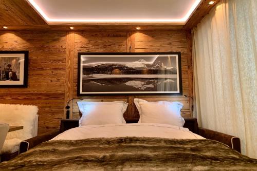 a bedroom with a bed and a picture on the wall at Apartment Au Reduit 208 in St. Moritz