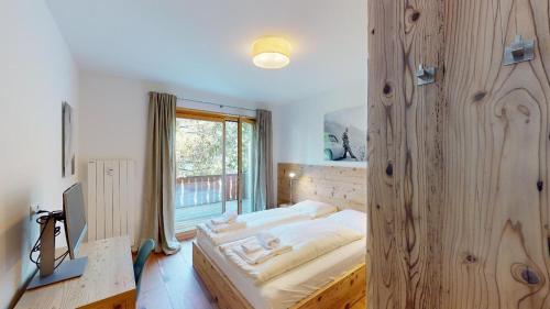 ein Schlafzimmer mit einem großen Bett mit einer Holzwand in der Unterkunft Apartment Sungold in St. Moritz