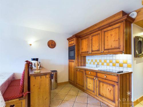 une cuisine avec des armoires en bois et un comptoir dans l'établissement Appartement 3 pièces Sud avec balcon, parking et proche pistes et commerces - FR-1-398-571, à La Rosière