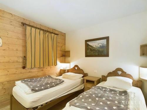 deux lits jumeaux dans une chambre aux murs en bois dans l'établissement Appartement 3 pièces Sud avec balcon, parking et proche pistes et commerces - FR-1-398-571, à La Rosière
