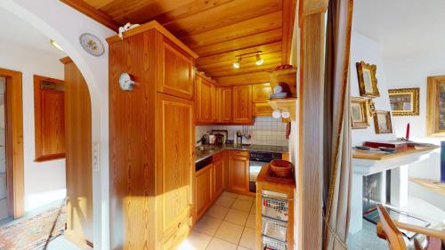 a kitchen with wooden cabinets and a counter top at Apartment Belvair 39 in Zuoz