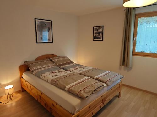 a bedroom with a bed in a room with a window at Cuntainta Champfer in Champfer
