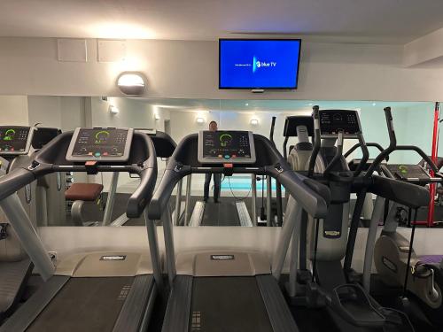 a gym with treadmills and a flat screen tv at Chesa Unica - Bijou in Zuoz