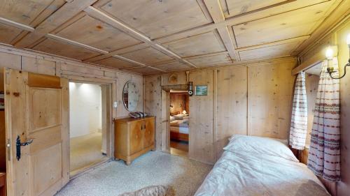 a bedroom with a bed and a wooden ceiling at Apartment Seraina in La Punt-Chamues-ch