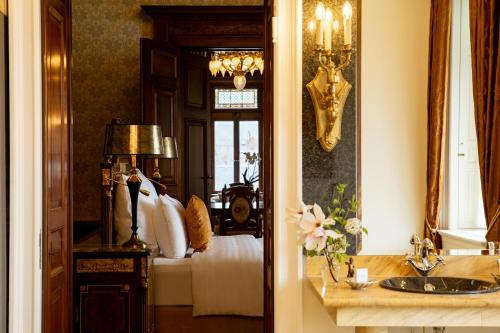 a bathroom with a bed and a sink and a mirror at Schloss Lieser, Autograph Collection in Lieser