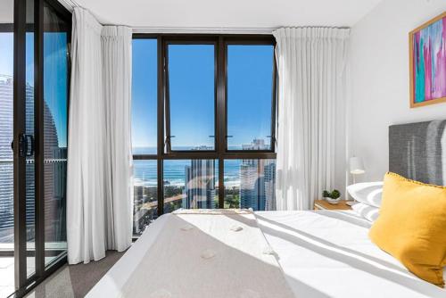 黄金海岸Modern 2BR Broadbeach Ocean Hinterland Views的一间卧室，里面有一张床和一扇大窗户。