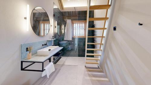 ein Badezimmer mit einer Treppe, einem Waschbecken und einem Spiegel in der Unterkunft Apartment Sella Nouva in Pontresina