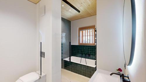 ein Badezimmer mit einem Waschbecken und einer Dusche mit grünen Fliesen in der Unterkunft Apartment Roseg Nouva in Pontresina