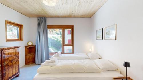 ein Schlafzimmer mit zwei Betten und einem Fenster in der Unterkunft Apartment Roseg Nouva in Pontresina