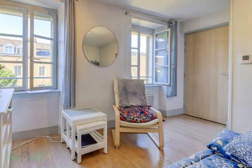 un salon avec une chaise et un miroir dans l'établissement Le Petit Monge Ultra centre Place Emile Zola, à Dijon