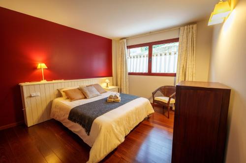 a bedroom with a bed and a red wall at Apartament Vega - Vall Fosca - L'Amfitriona in Espúy