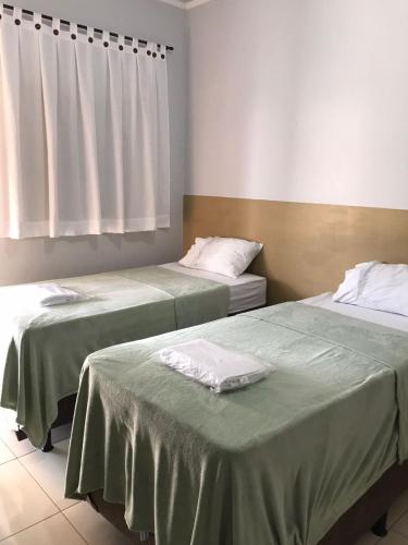 two beds sitting next to each other in a room at Hotel El Shaday in Nazário