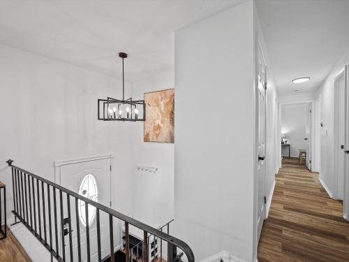 a staircase with white walls and a chandelier at Modern and Accessible 5 Bedroom Home in Cranberry, Pittsburg with Game Room in Cranberry Township