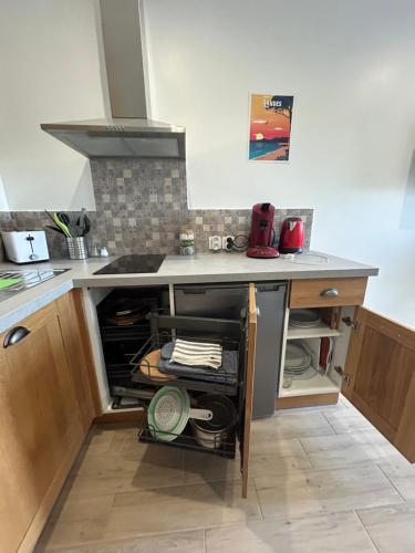a kitchen with a stove and an open drawer at Studio complet neuf en rdc in Dax