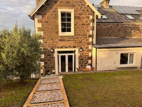 a brick house with a pathway in front of it at The Garden Rooms in Newport-On-Tay