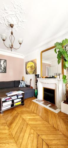 un salon avec une cheminée et un miroir dans l'établissement Charming Nest in Paris-Pont Cardinet, à Paris